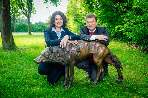 Elisabeth Haselberger und Florian Leebmann mit einer Wolfsstatue aus Bronze