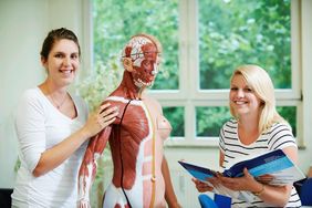 Schüler bereiten sich auf den Anatomieunterricht vor mit Hilfe eines menschlichen Modells